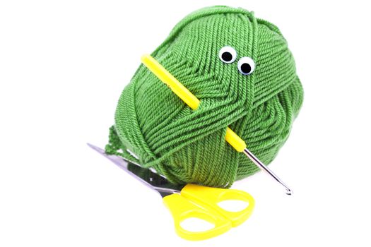 skein of wool  with eyes, scissors and crochet hooks isolated on