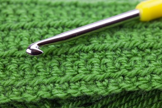  crochet hook  and knitted piece background