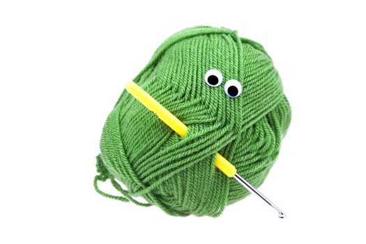 skein of wool  with eyes and crochet hooks isolated on white