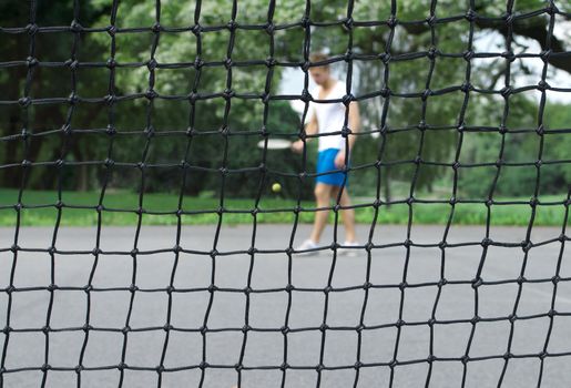 Tennis player seen through the net