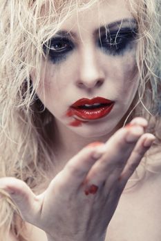 Blond lady with strange makeup. Vertical photo