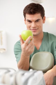 Smiling Male Dentist with Apple