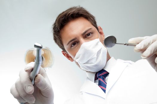 Dentist Holding Angled Mirror And Drill