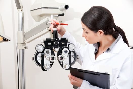 Female optometrist looking at phoropter.
