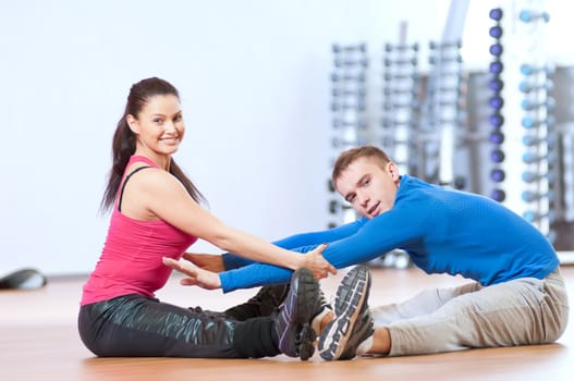 Man and woman at the gym doing stretching