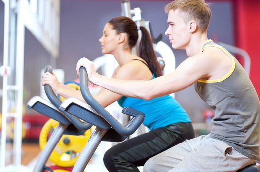 People in the gym doing cardio cycling training