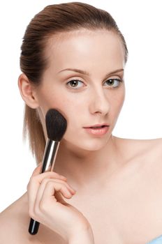 Beautiful young adult woman applying cosmetic brush