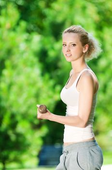 Woman doing dumbbell exercise outdoor