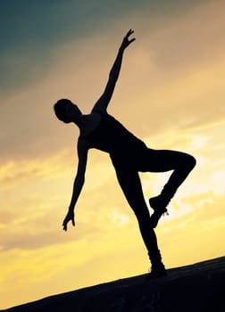 Silhouette of dancing woman over sunset. Yoga