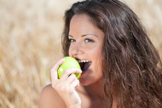 Perfect woman eating apple in dield. Summer picnic.