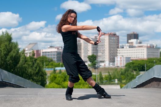 Beautiful girl dancing modern style over city landscape