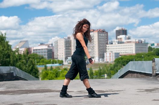 Beautiful girl dancing modern style over city landscape