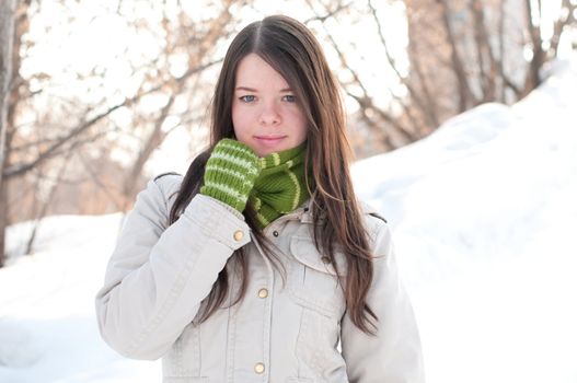 Beautiful girl in green over winter landscape