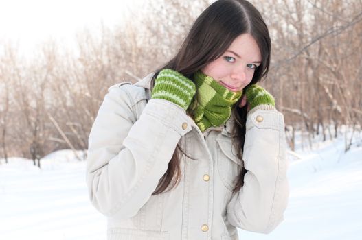 Beautiful girl in green over winter landscape