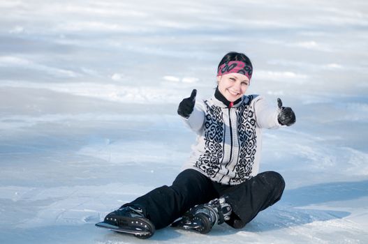 Ice skating woman sitting on ice