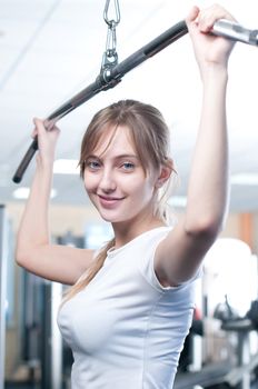 Powerful casual woman lifting weights in gym