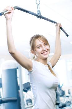 Powerful casual woman lifting weights in gym