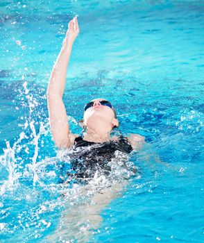 Swimmer in swim meet doing backstroke
