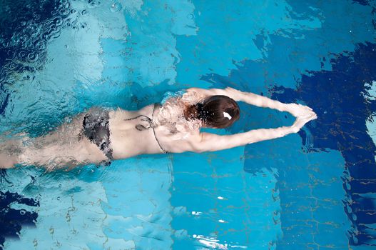 Athletic swimmer is diving in a swimming pool