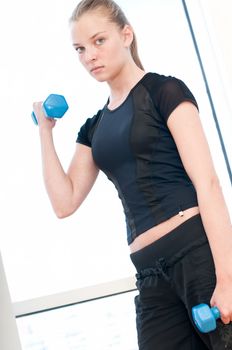 Young woman doing dumbbell exercises