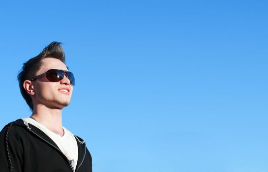 Close up of teenager over blue sky