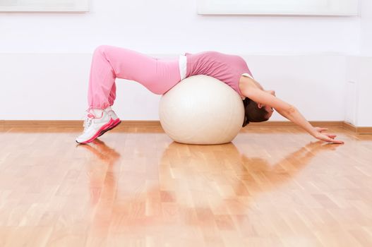 Woman doing stretching exercise on ball
