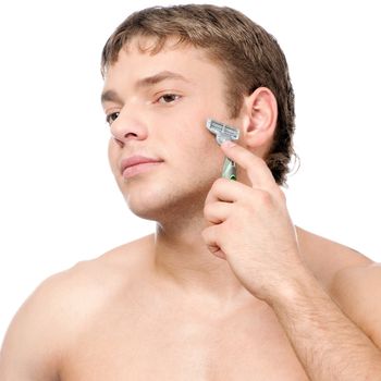 Portrait of a young handsome man shaving