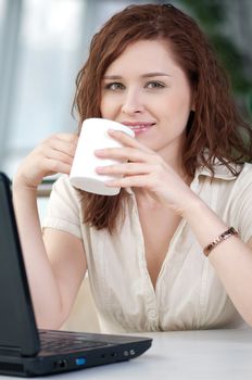 Business woman with a laptop and mug