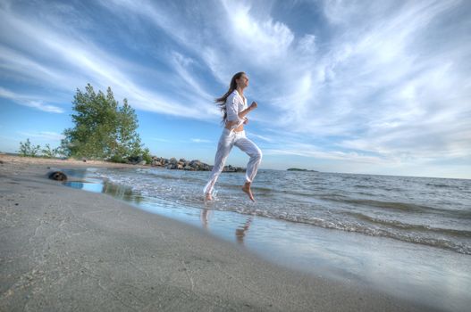 Sporty woman running in sea coast