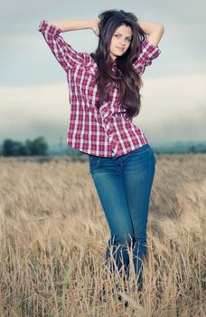 Beautiful cowboy woman posing in field