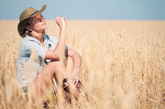 Cowboy woman in country wheat field