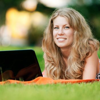 Young woman with laptop at park