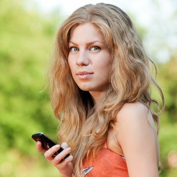 Young happy woman texting on mobile phone. SMS