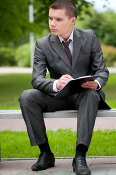 business man working with papers at park. Student