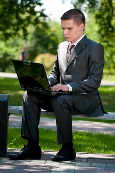 business man work on notebook at park. Student