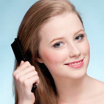 Close up portrait of young beautiful woman with comb