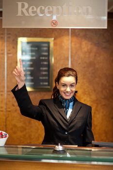 Beautiful female receptionist indicating upwards