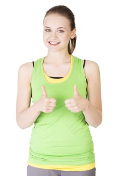 Fitness woman in sport clothes gesturing thumbs up