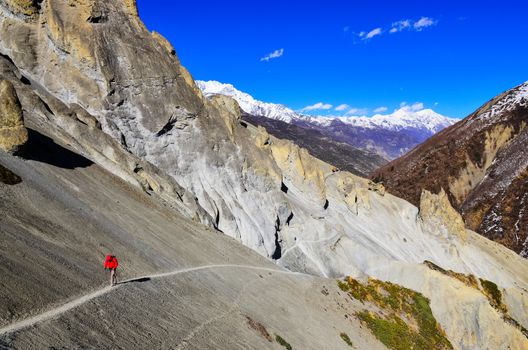 Trekker in red jacket in Himalayas mountains