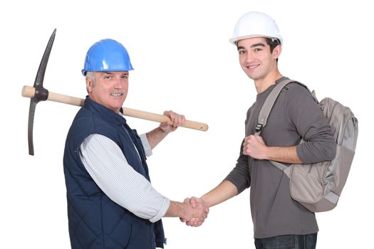 Laborer welcoming young teenage apprentice