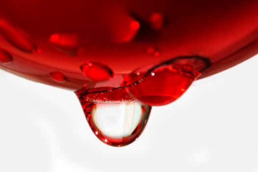 Water drop from red sphere