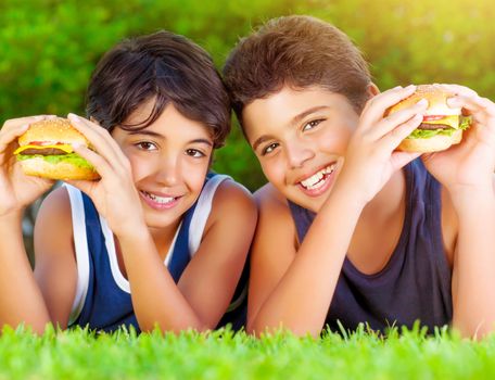 Two boys eating burgers