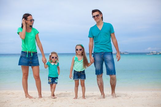 Young beautiful family of four enjoyed relaxing on the beach