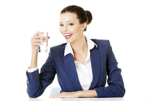 Businesswoman sitting at the desk and drinking mineral water