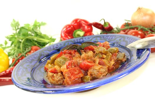Tunisian tagine Kefta with tomatoes, peppers and ground beef on a light background