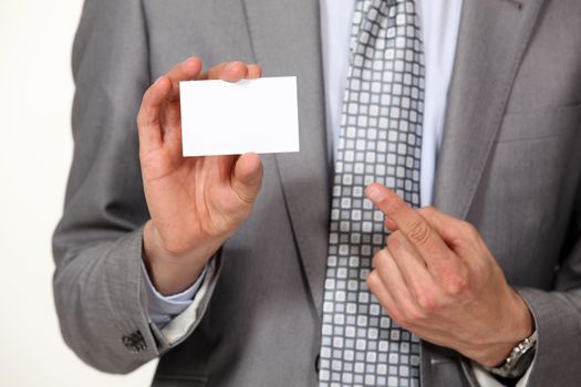 A cropped picture of a businessman showing his card.