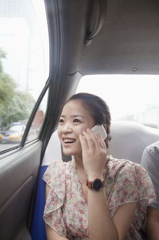 Young Woman With Cell Phone In Taxi