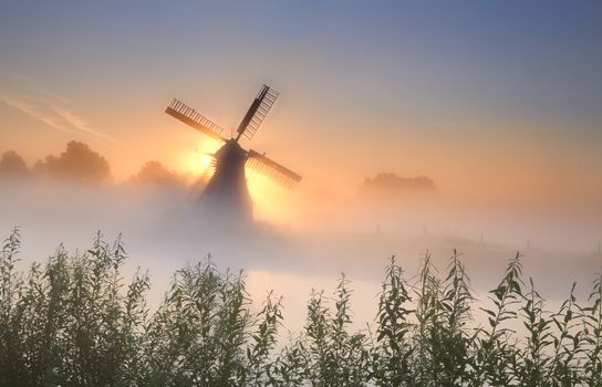 misty sunrisebehind the windmill