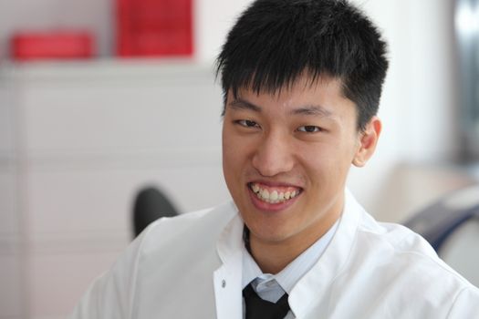 Smiling Asian man in a lab coat