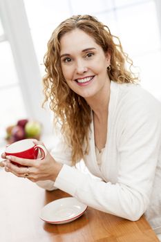 Smiling woman holding red coffee cup